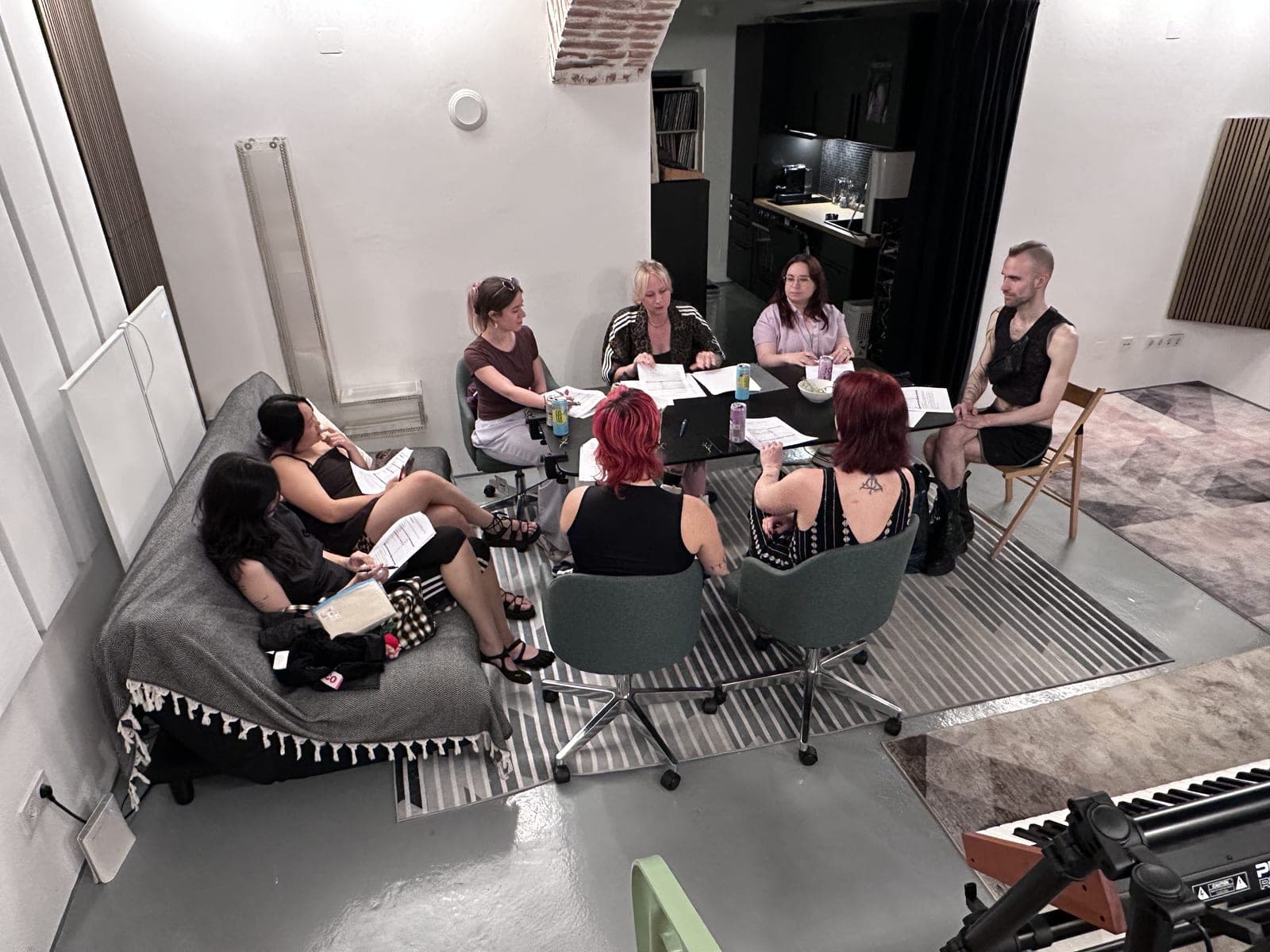 A course group in the studio: people sitting in a circle working with handouts.