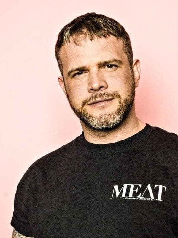 Gerald VDH in a black MEAT shirt against a pink background.